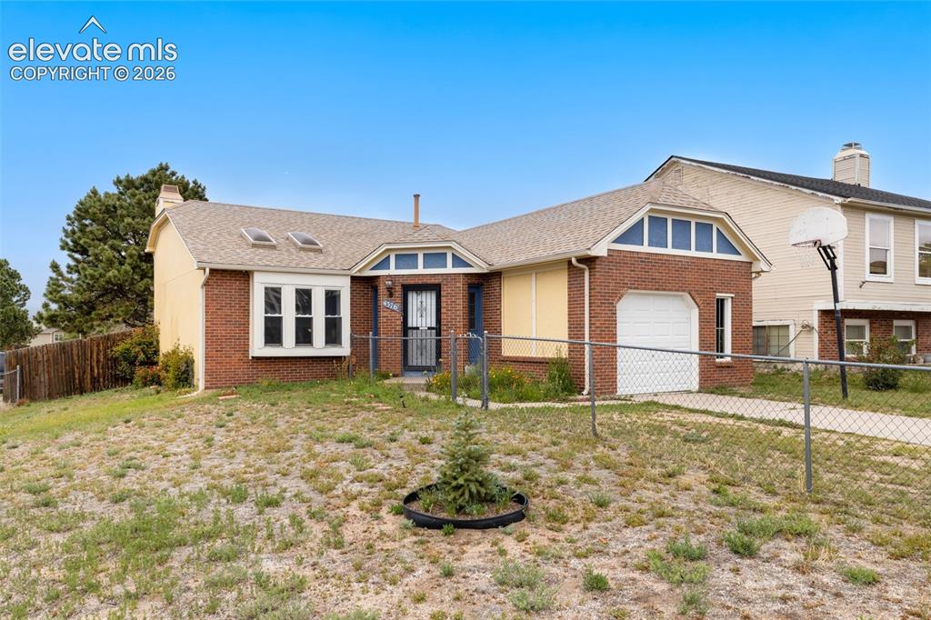 Image 9 of 43: Brick and stucco exterior featuring a bay window, skylights, and an attache