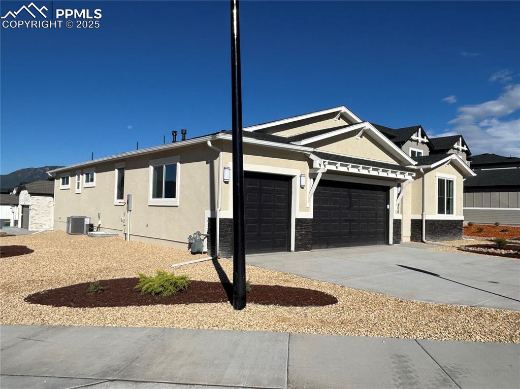 Image 3 of 3: View of property exterior featuring stucco siding, concrete driveway, a gar