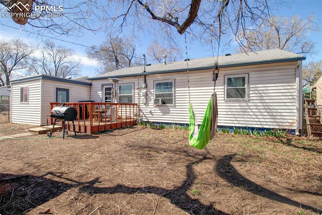 Image 21 of 21: Another view of the backyard showin entrance to the apartment and small dec