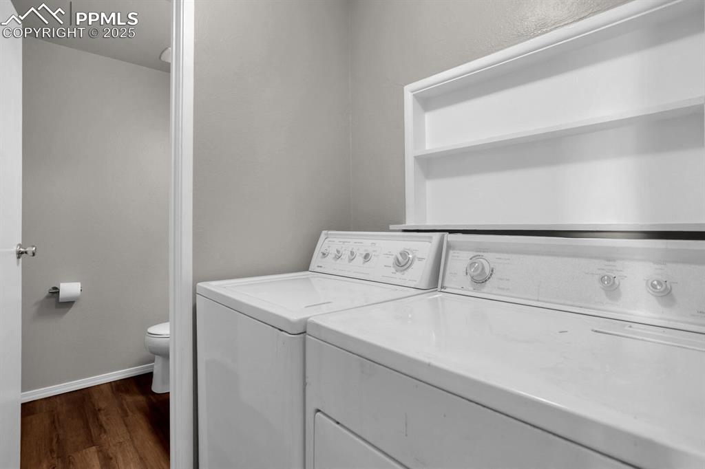 Image 10 of 28: Laundry room featuring washing machine and dryer, dark wood-style flooring,