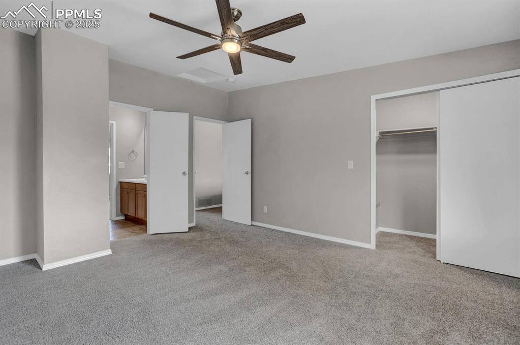 Image 17 of 28: Unfurnished bedroom with light colored carpet, a closet, ensuite bath, and