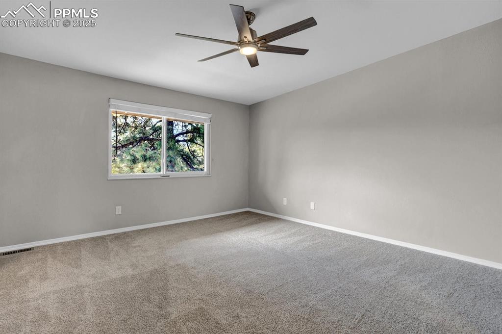Image 18 of 28: Spare room with a ceiling fan, carpet, and baseboards