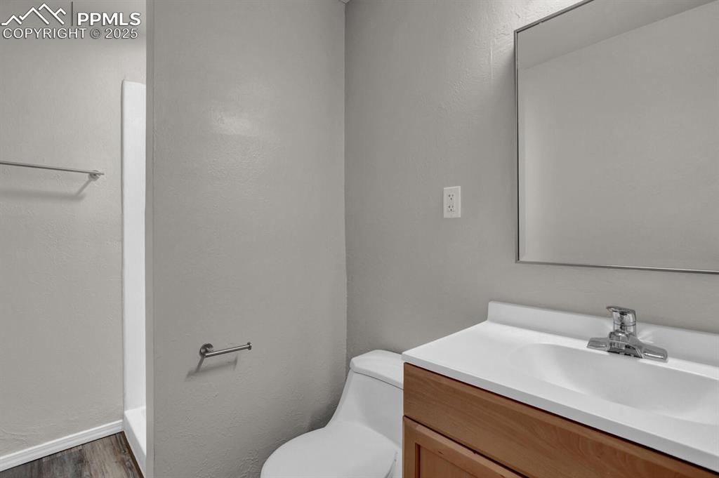 Image 21 of 28: Bathroom featuring wood finished floors, vanity, toilet, and baseboards