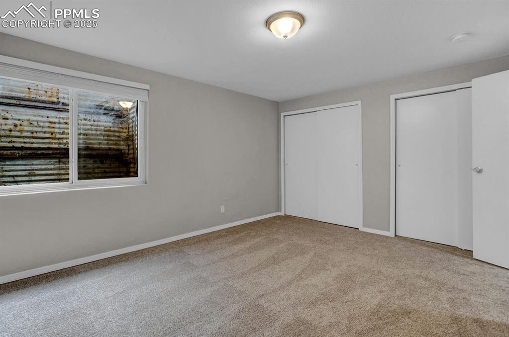 Image 23 of 28: Unfurnished bedroom with multiple closets, carpet, and baseboards