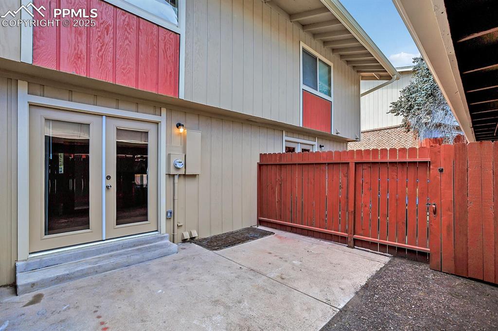 Image 25 of 28: View of exterior entry featuring a patio area, fence, and french doors