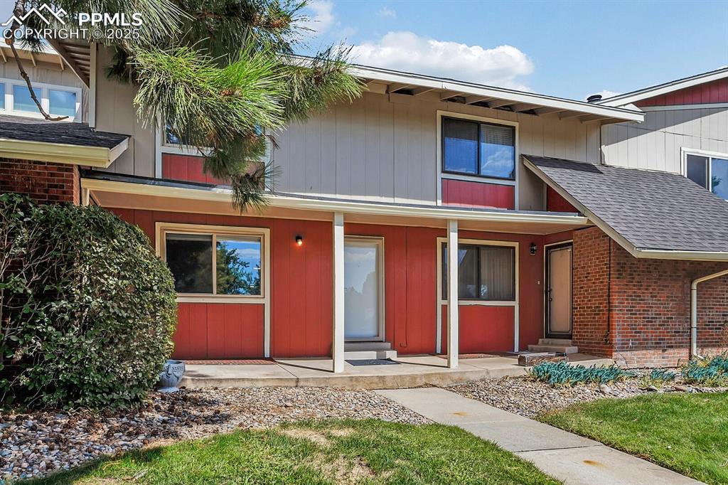Image 3 of 28: Townhome / multi-family property featuring covered porch, brick siding, and