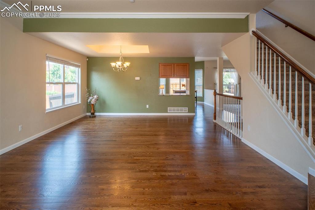 Image 2 of 37: Enter to an expansive great room with gleaming hardwood floors