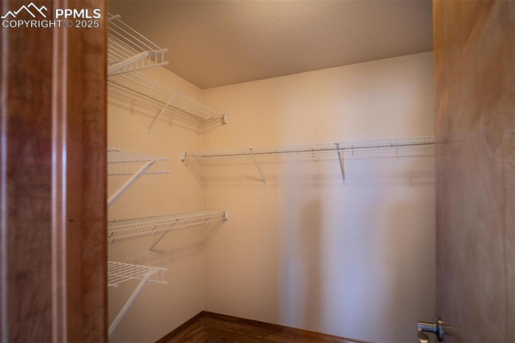 Image 20 of 37: The primary walk-in closet offers an abundance of space and is lined with c