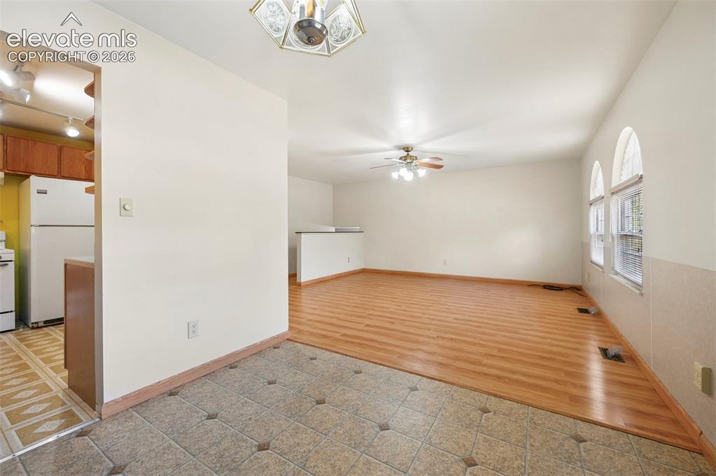 Image 15 of 50: Tiled entry flooring, wood-finish flooring, half-wall partition, arched win