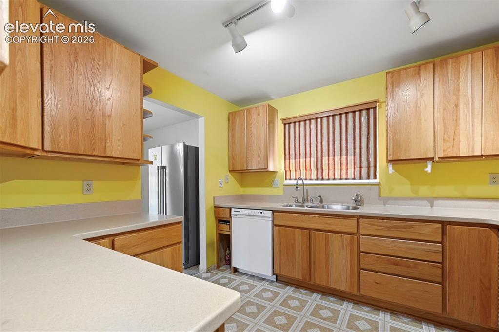 Image 18 of 50: Kitchen featuring wood cabinetry, light-toned countertops, a stainless stee