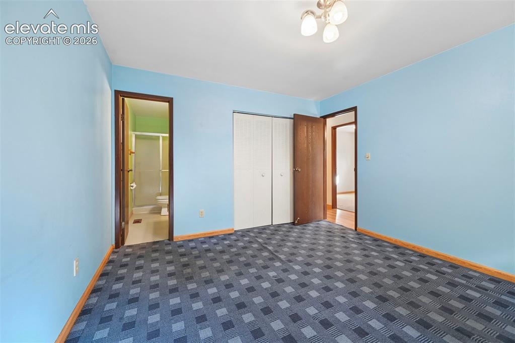 Image 20 of 50: Wall-to-wall patterned carpeting, built-in closet with bi-fold doors, and a