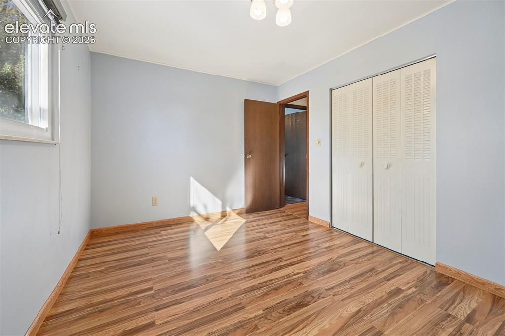 Image 25 of 50: Wood-finish flooring, bi-fold louvered closet doors, and an overhead flush-