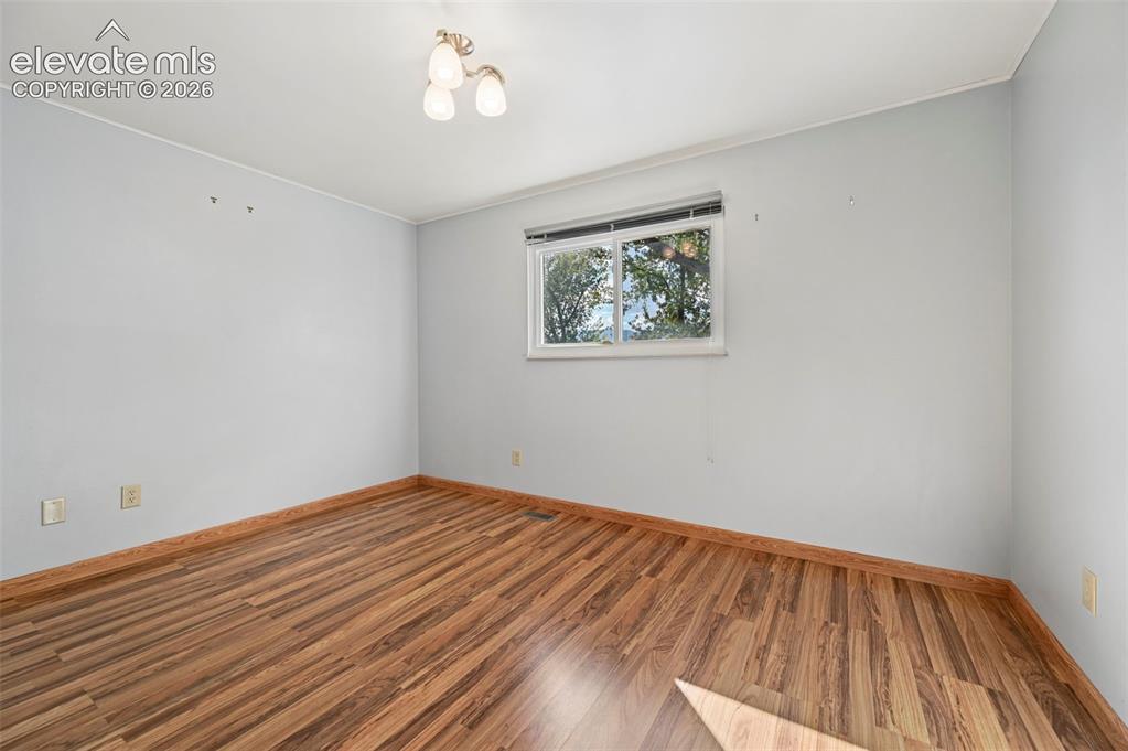 Image 26 of 50: Wood-finish flooring, white walls, and a multi-pane window
