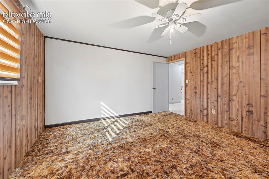 Image 37 of 50: Wall-to-wall carpeting, wood-paneled wall accents, white painted wall, ceil