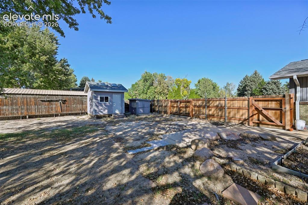 Image 41 of 50: Expansive outdoor space featuring a wood privacy fence, a detached storage