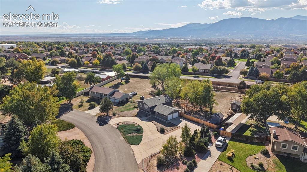 Image 47 of 50: Expansive neighborhood setting with mature trees and mountain scenery
