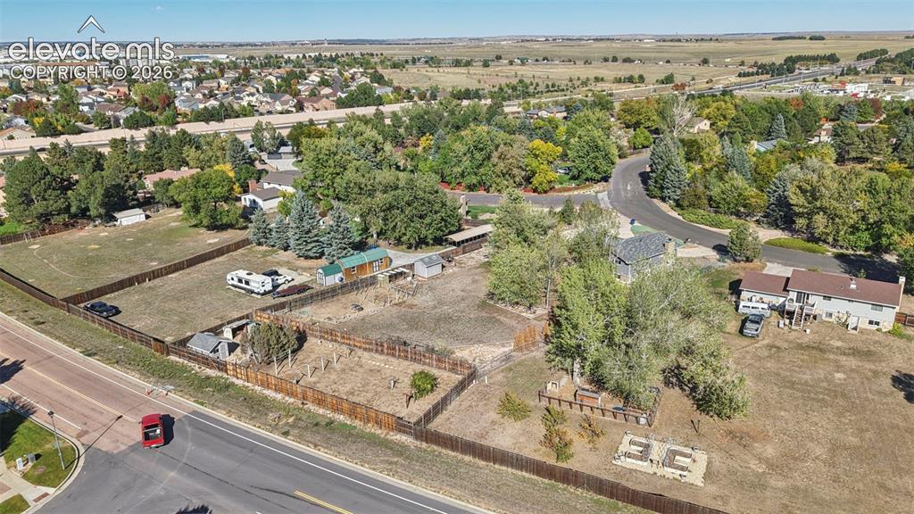 Image 50 of 50: Expansive fenced lot featuring mature trees, a detached storage shed, and a