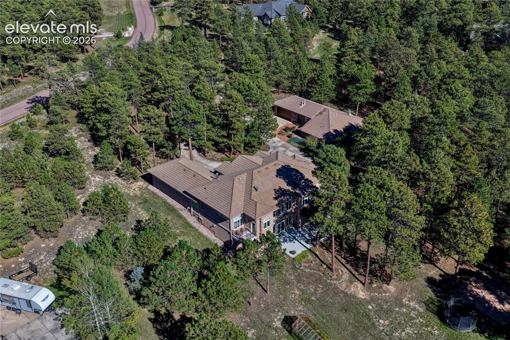 Image 4 of 50: Aerial perspective of a multi-level residence featuring a multi-pitched roo