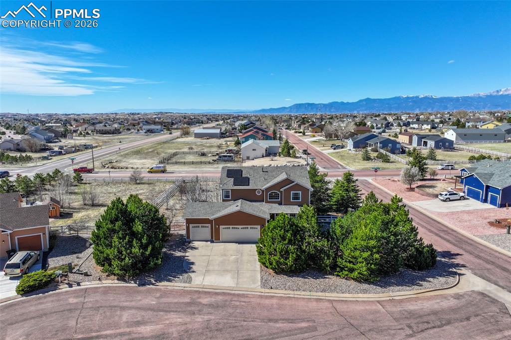Image 2 of 49: Aerial view of residential area featuring a mountainous background