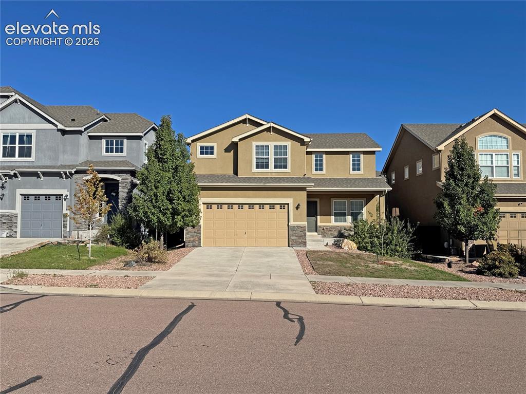 Image 1 of 42: Two-story exterior featuring a stucco and stone facade, attached two-car ga