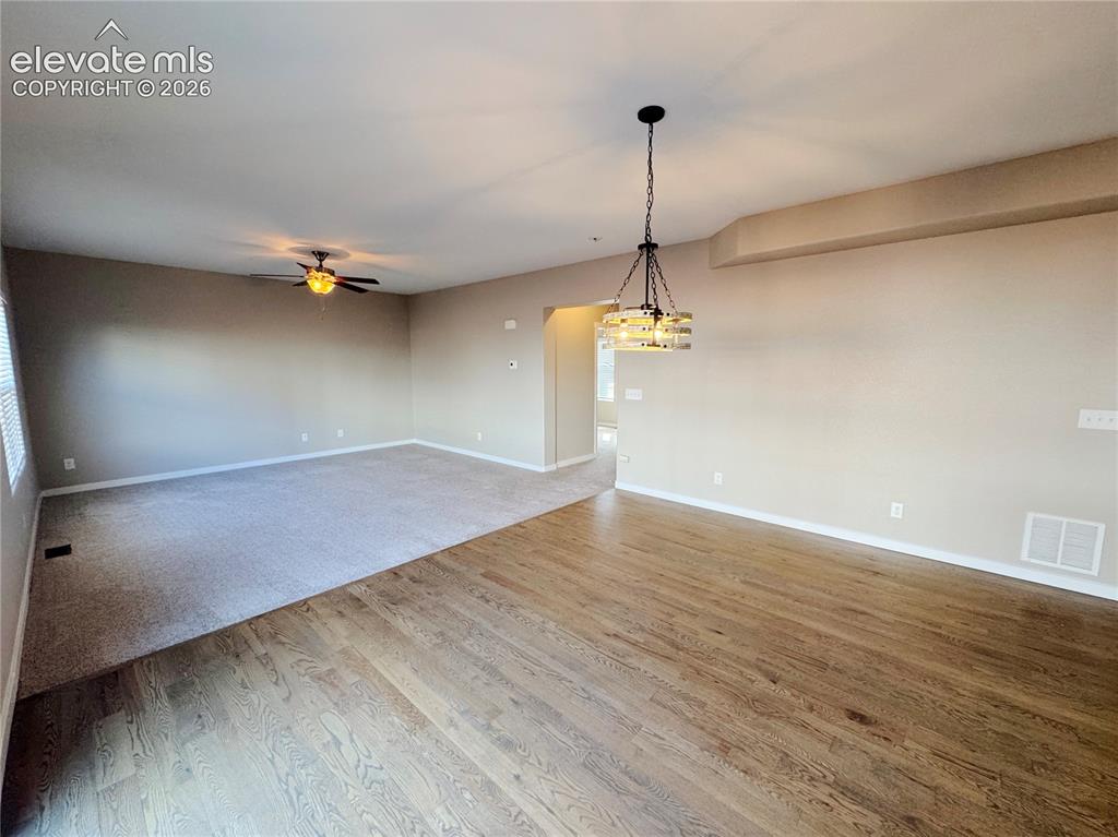 Image 11 of 42: Open-concept space featuring wood-finish flooring, neutral wall tones, a ce