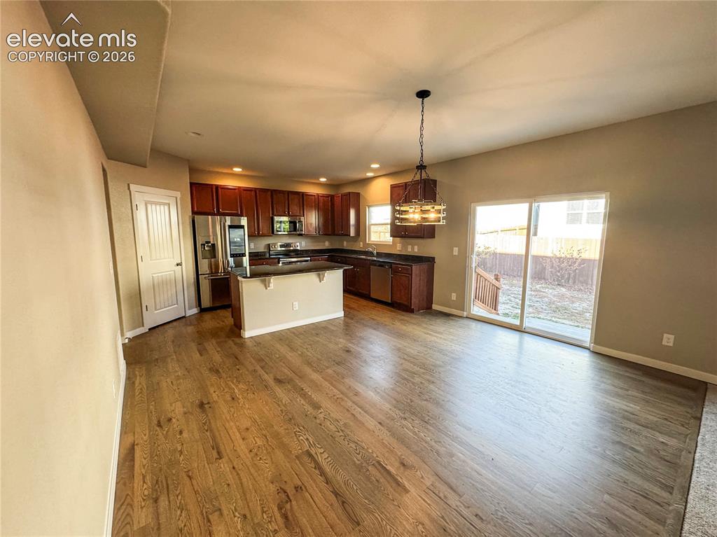 Image 14 of 42: Kitchen featuring dark-toned cabinetry, stainless steel appliances, a penin