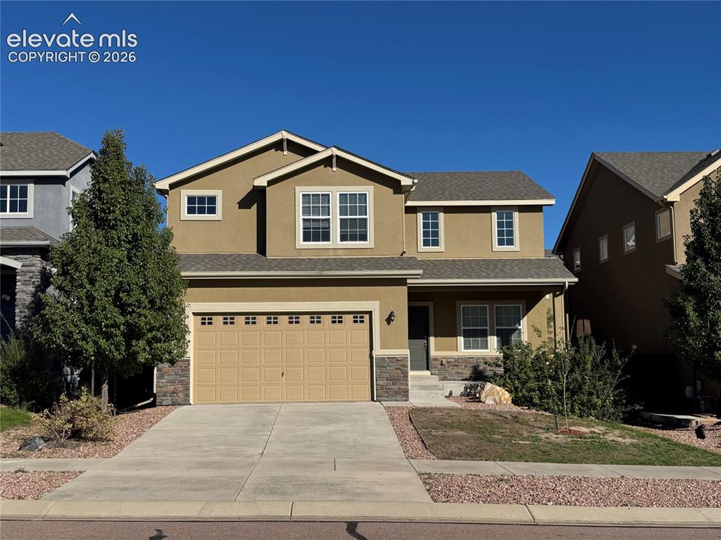 Image 2 of 42: Two-story exterior featuring a neutral stucco facade, stacked stone accents