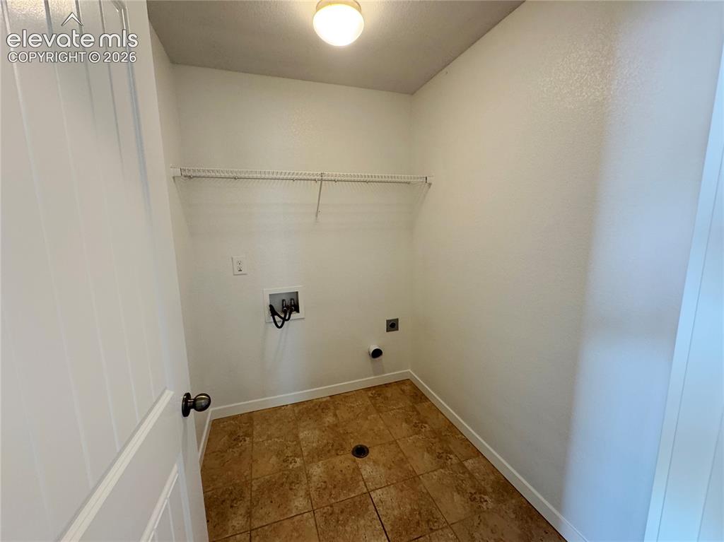 Image 27 of 42: Utility area featuring tile flooring, ceiling-mounted lighting, wall-mounte