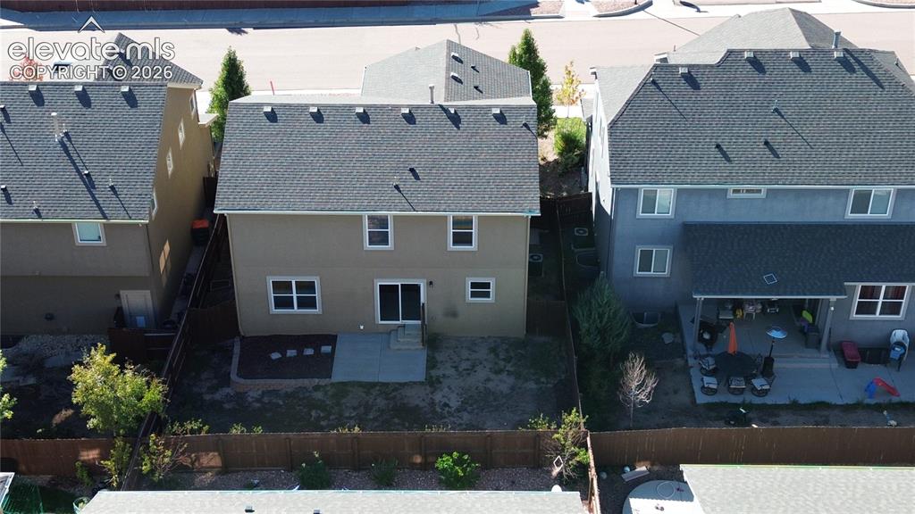 Image 3 of 42: Backyard featuring a concrete patio, perimeter wood fencing, and designated
