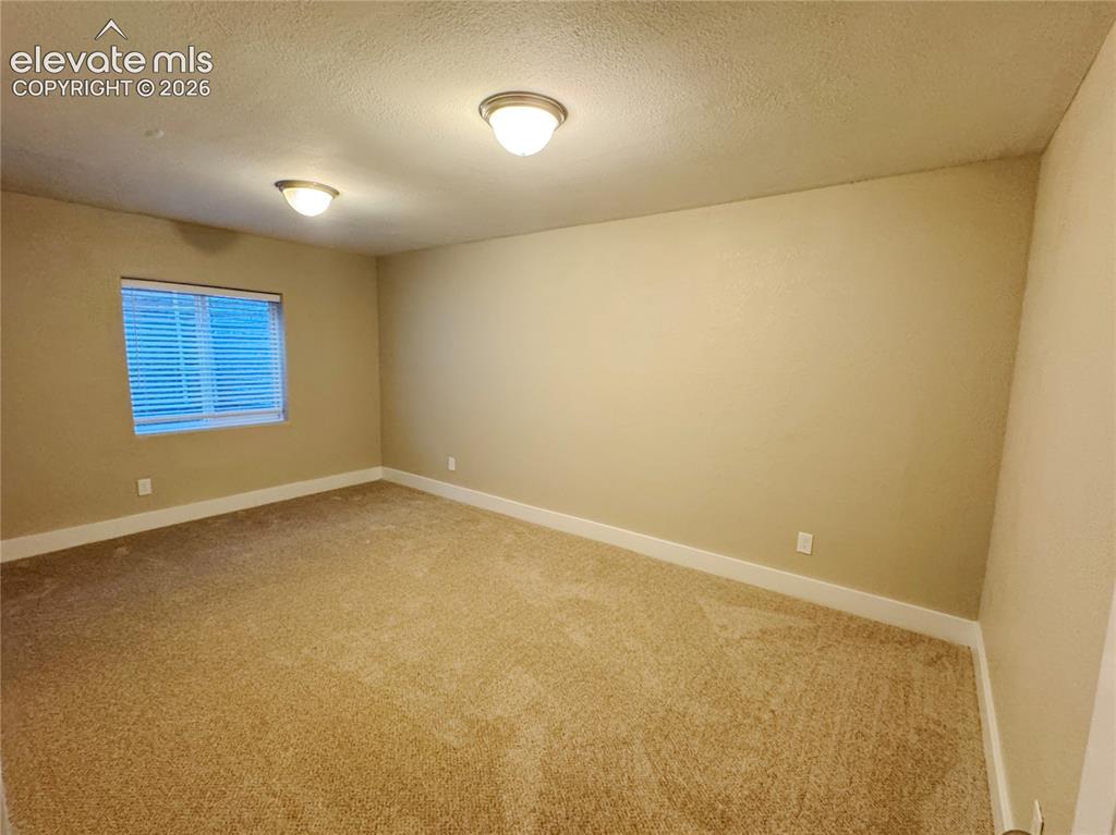 Image 39 of 42: Neutral-toned interior space featuring carpeted flooring, two semi-flush mo