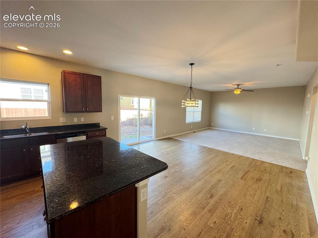 Image 8 of 42: Kitchen area featuring a dark-finish kitchen island with stone countertop,