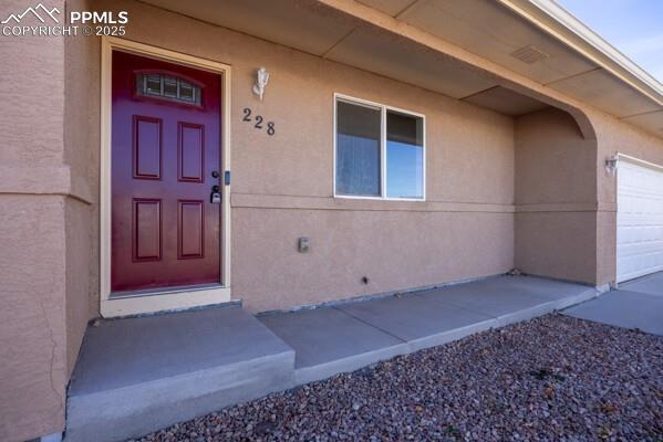 Caption: View of exterior entry featuring stucco siding