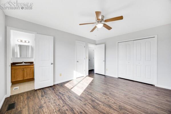 Image 14 of 26: Unfurnished bedroom featuring dark wood-type flooring, ceiling fan, a close