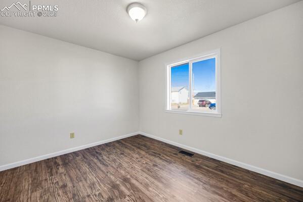 Image 19 of 26: Empty room featuring dark wood-style floors and a textured ceiling