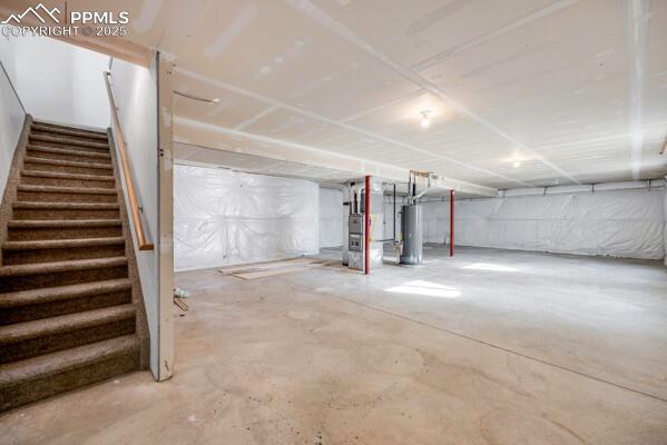 Image 20 of 26: Unfinished basement with heating unit and water heater