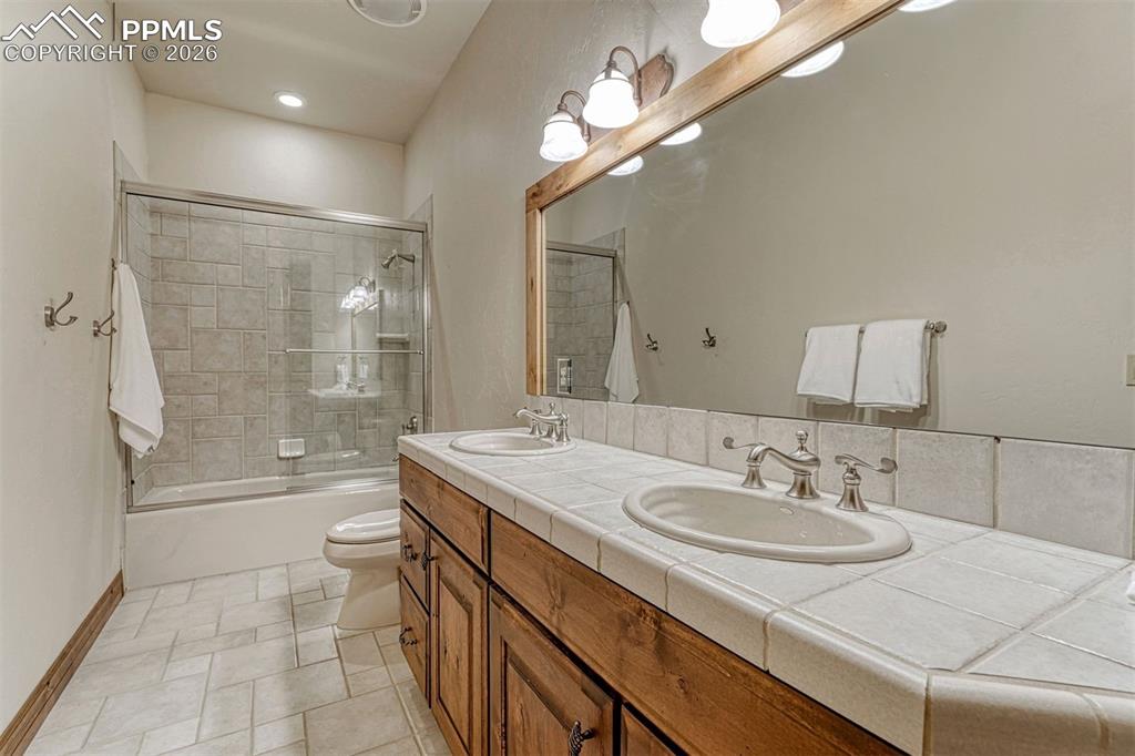 Image 18 of 50: Generous guest suite bath with dual sink vanity.