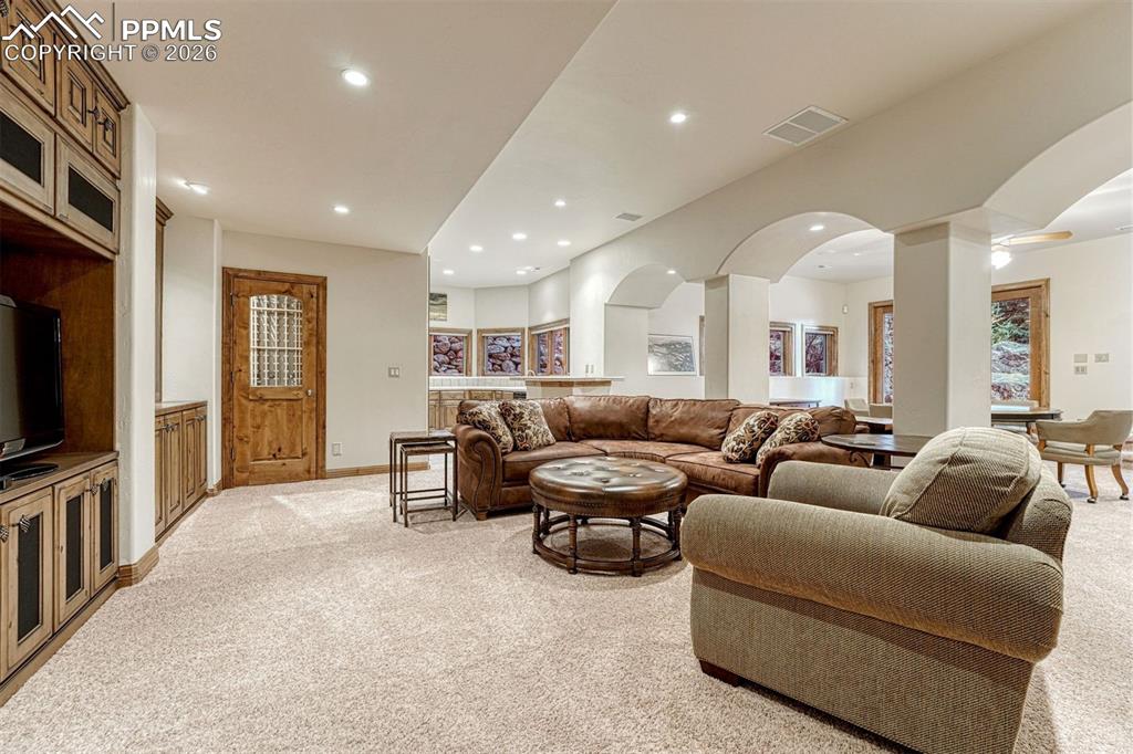Image 24 of 50: A sophisticated lower level with custom built-ins, media area, wine cellar,