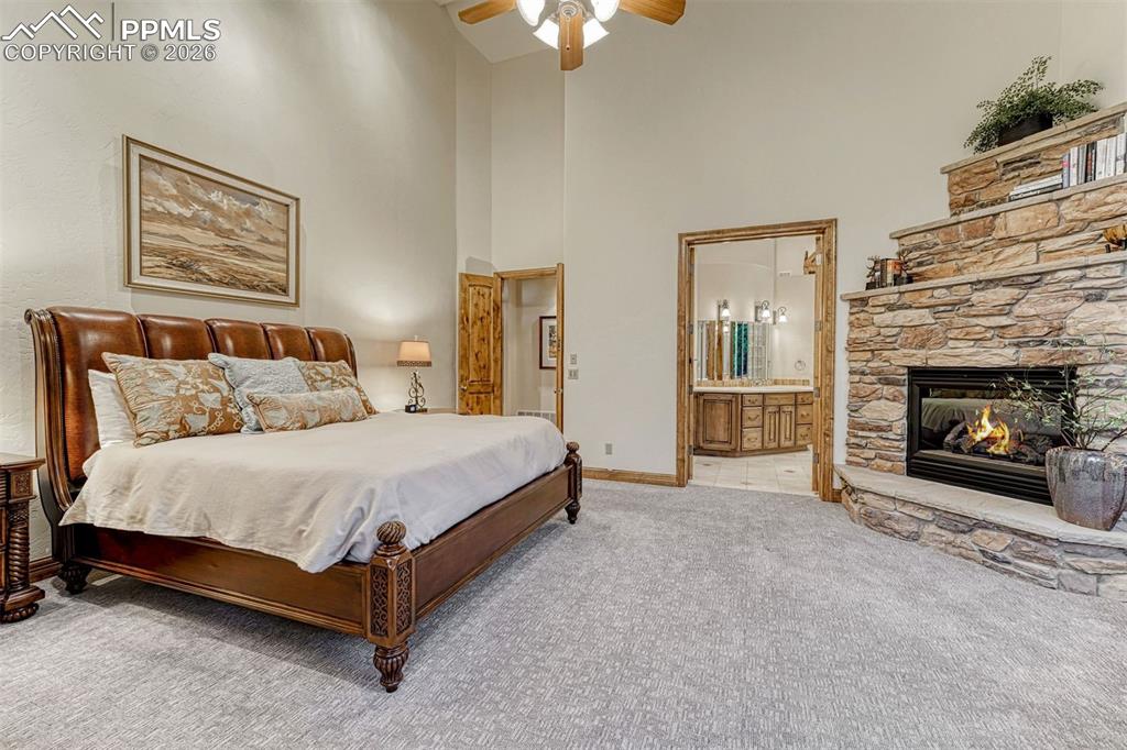 Image 33 of 50: Primary bedroom with a cozy, elegant gas fireplace.