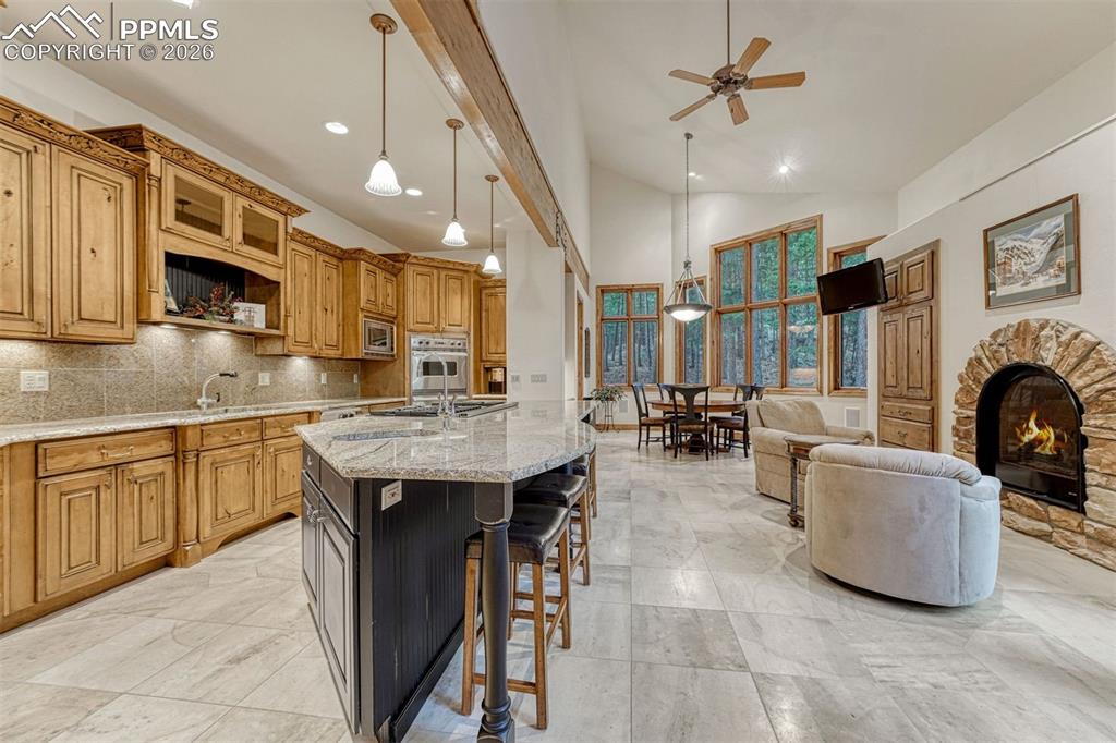 Image 9 of 50: Spacious kitchen with slab granite counters and distressed maple cabinetry.