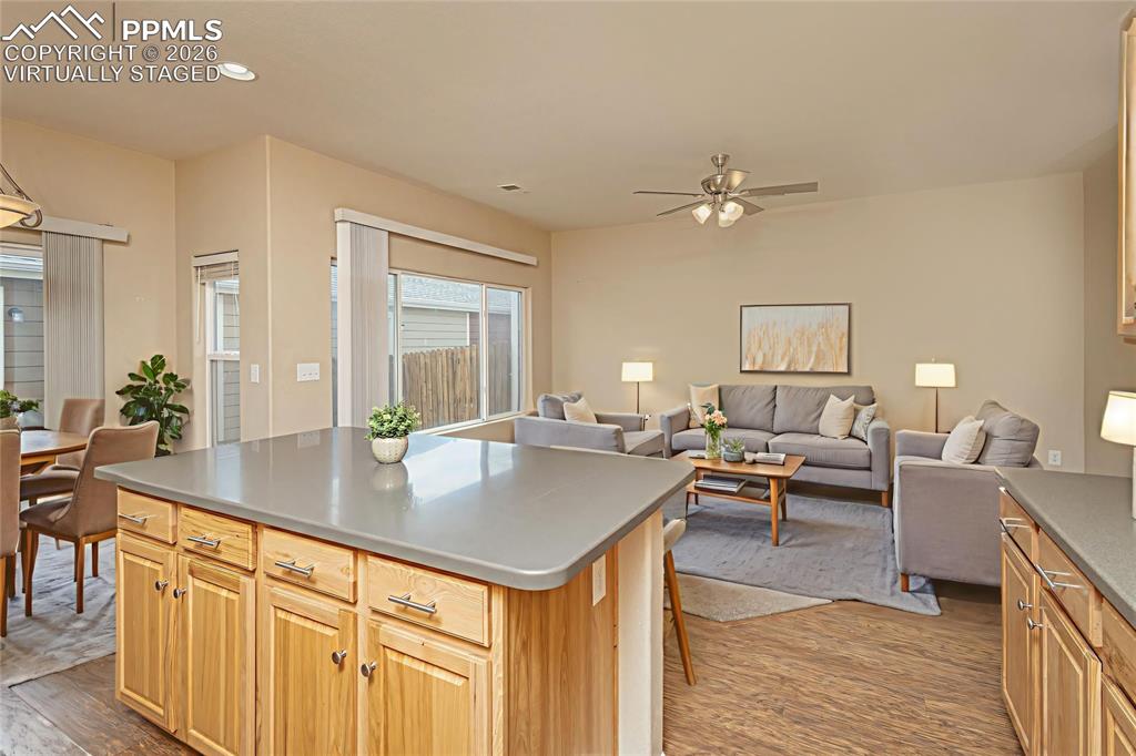 Image 10 of 33: Kitchen with a kitchen island, open floor plan, ceiling fan, light wood fin