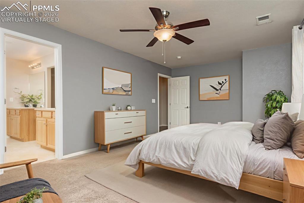 Image 12 of 33: Bedroom featuring light colored carpet, ceiling fan, and ensuite bathroom V