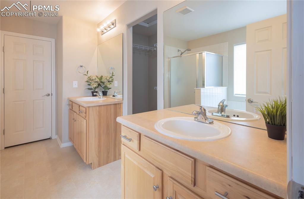 Image 13 of 33: Full bath with two vanities and a shower stall