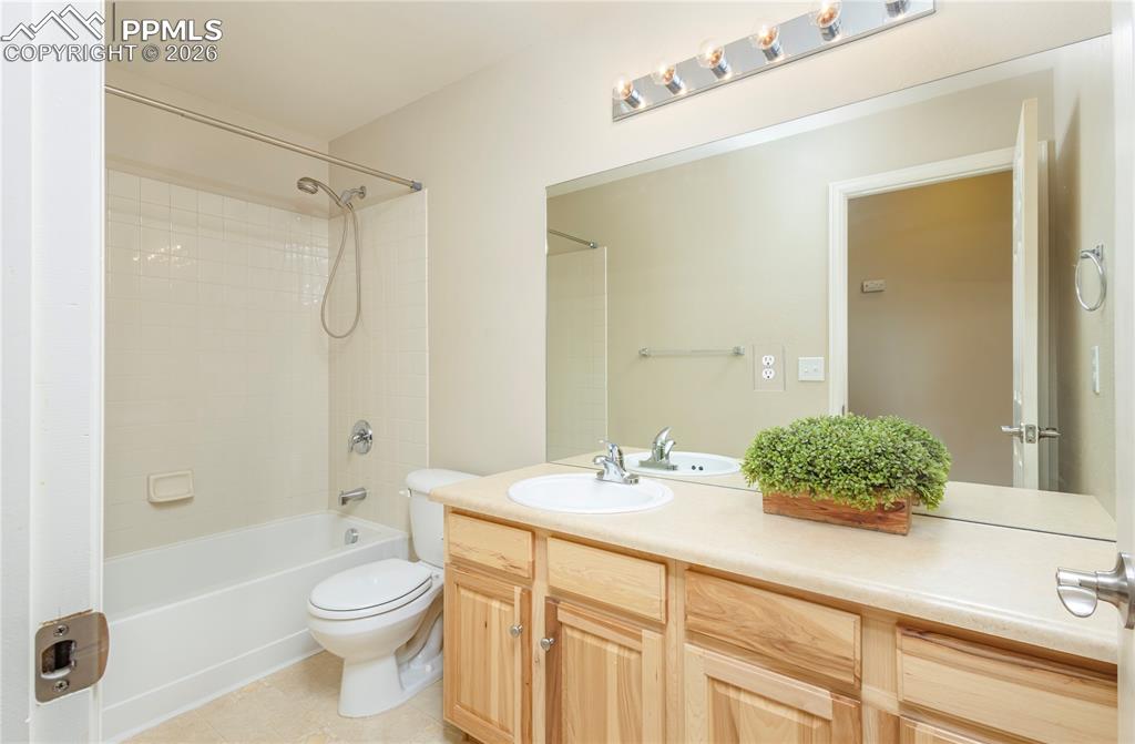 Image 16 of 33: Bathroom with vanity, washtub / shower combination, and light tile patterne