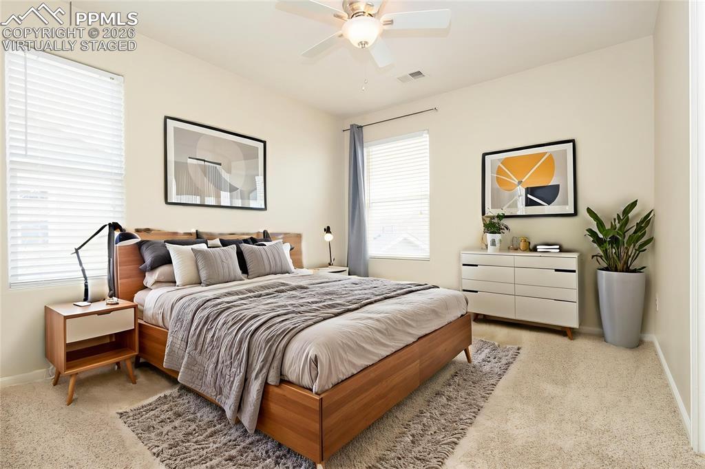 Image 17 of 33: Bedroom with light carpet and a ceiling fan Virtually Staged