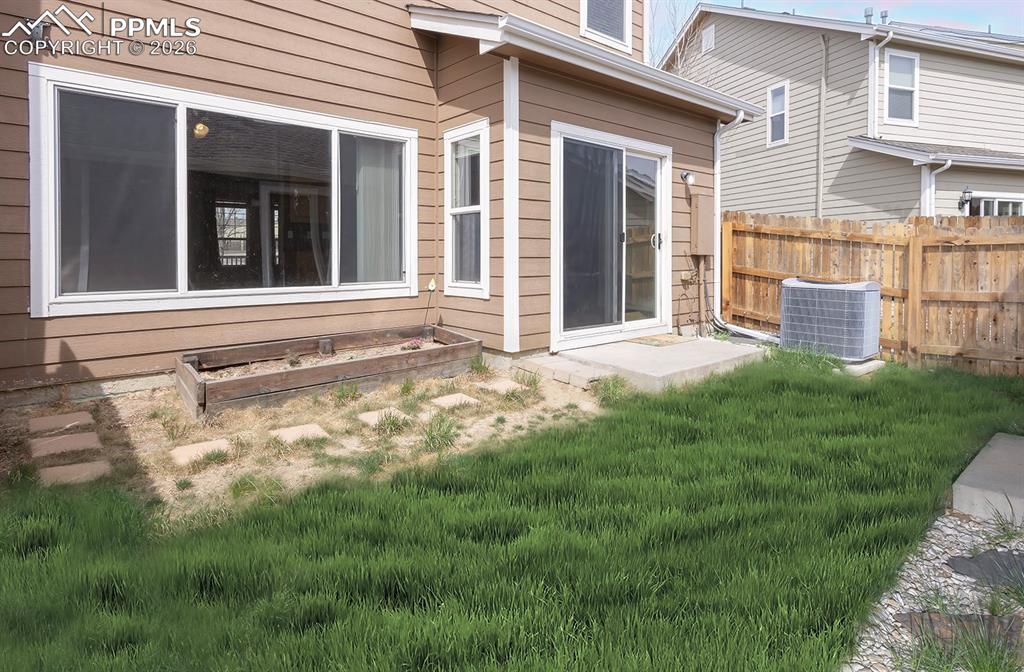Image 18 of 33: Rear view of property featuring a vegetable garden and a patio area