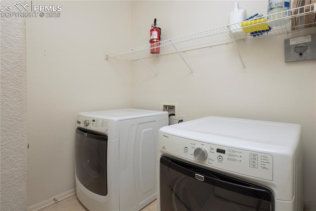 Image 19 of 33: Laundry area with washing machine and dryer and baseboards