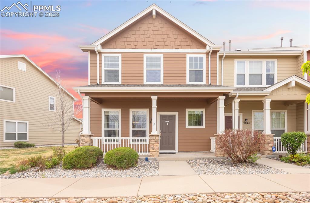 Image 2 of 33: Craftsman-style home with covered porch and stone siding