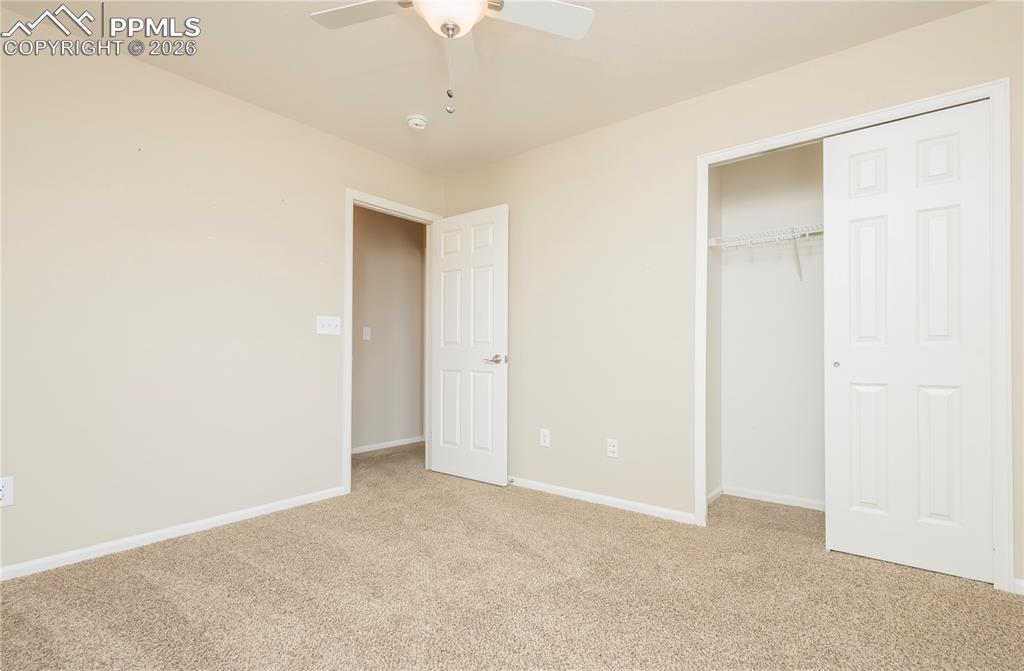 Image 23 of 33: Unfurnished bedroom with light colored carpet, a closet, and a ceiling fan