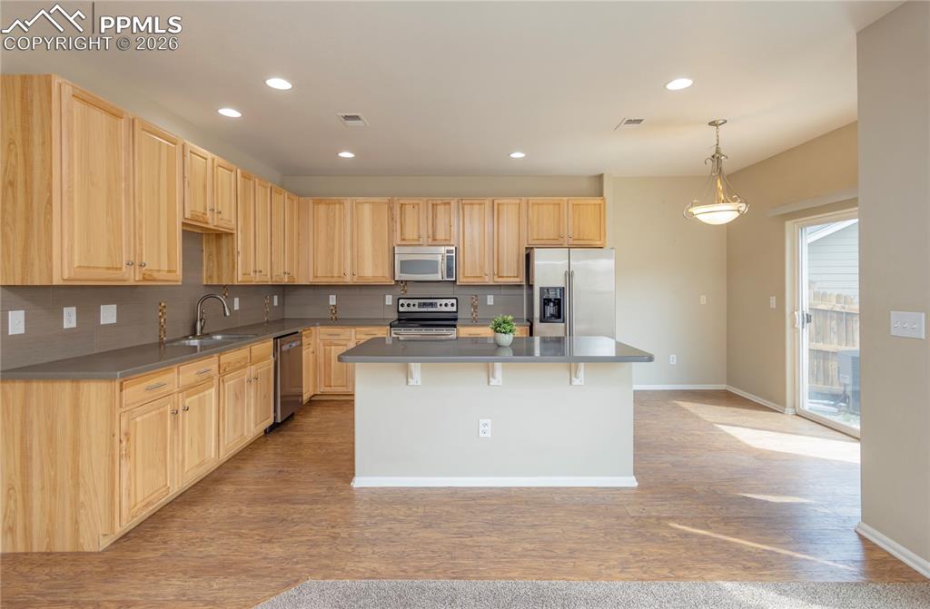Image 29 of 33: Kitchen with light wood finish cabinetry, stainless steel appliances, and t