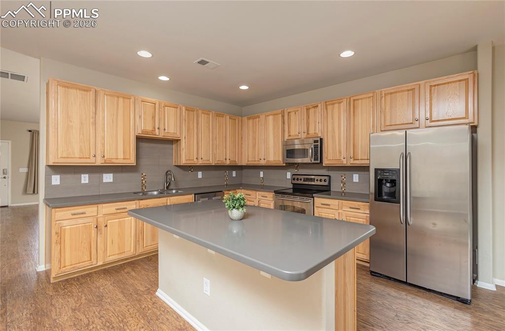Image 30 of 33: Kitchen featuring light wood finish cabinetry, stainless steel appliances,